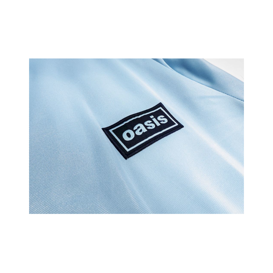 Chamarra Oasis x Adidas Live '25 Celeste - detalle del parche Oasis