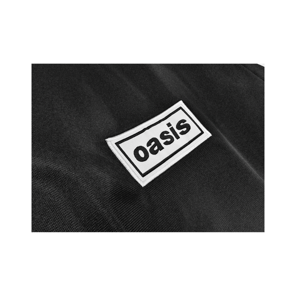 Chamarra Oasis x Adidas Live '25 Negra - detalle del parche Oasis