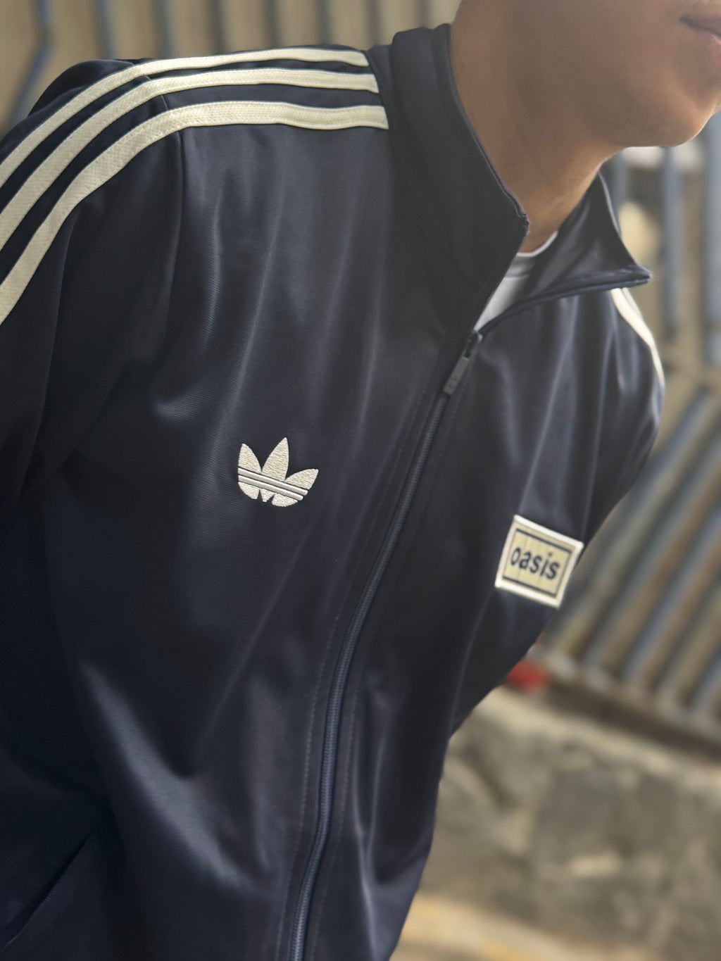 Detalle de la Chamarra Oasis x Adidas Live '25 Azul Marino puesta
