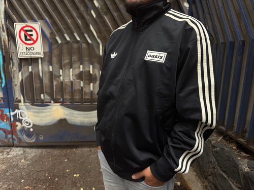 Modelo con la Chamarra Oasis x Adidas Live '25 Negra