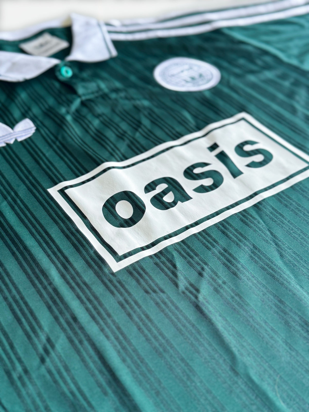 Logo Oasis de la Playera Oasis x Adidas Live '25 Verde