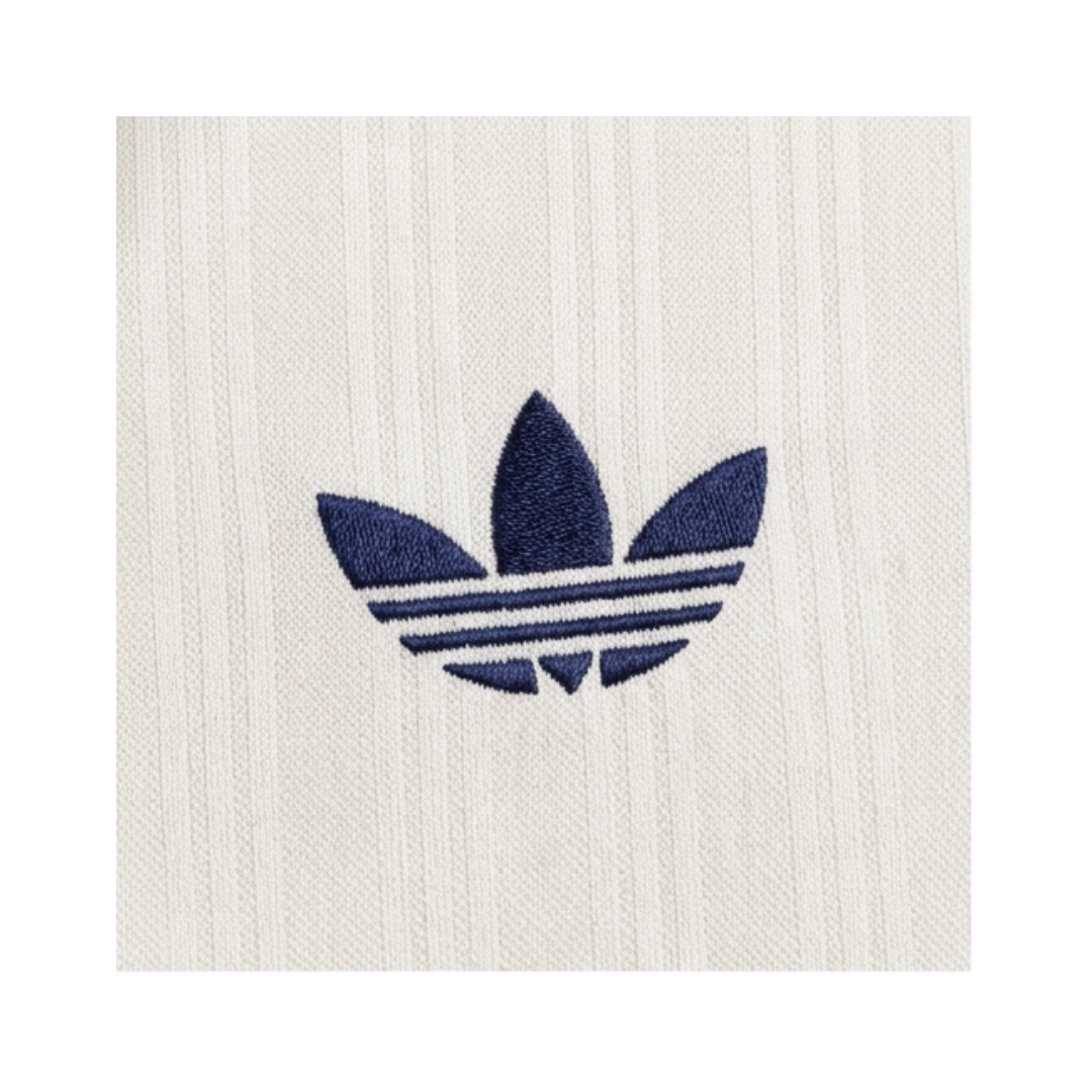 Playera Oasis x Adidas Live '25 Blanca - detalle del trébol Adidas