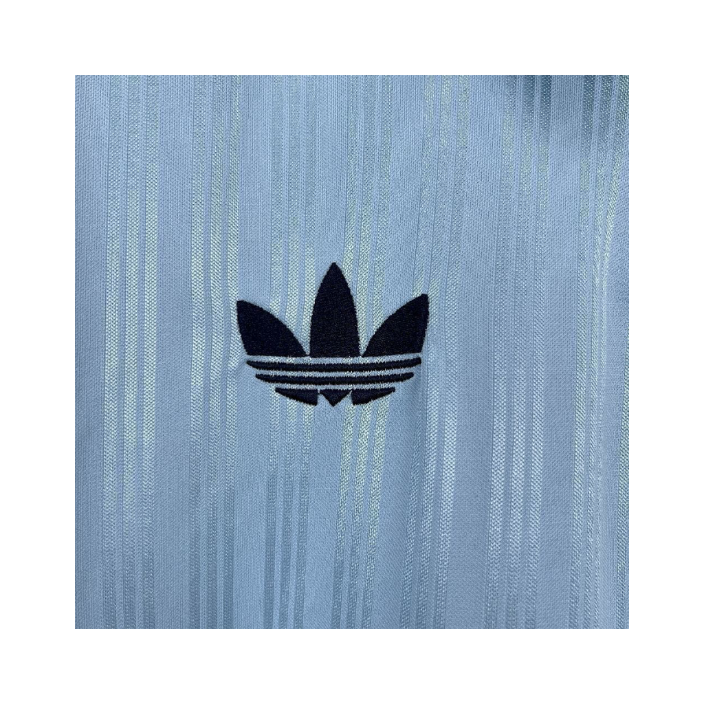 Playera Oasis x Adidas Live '25 Celeste - detalle del trébol Adidas